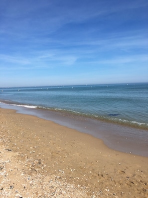A beach with a sandy shore and calm water. - Cozy duplex, direct access, free Wi-Fi on the beach (Merville-Franceville-Plage)
