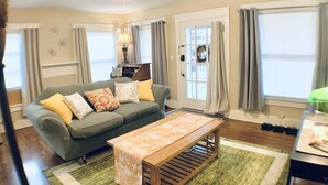 A living room with a grey sofa, a wooden coffee table, and a ceiling fan.