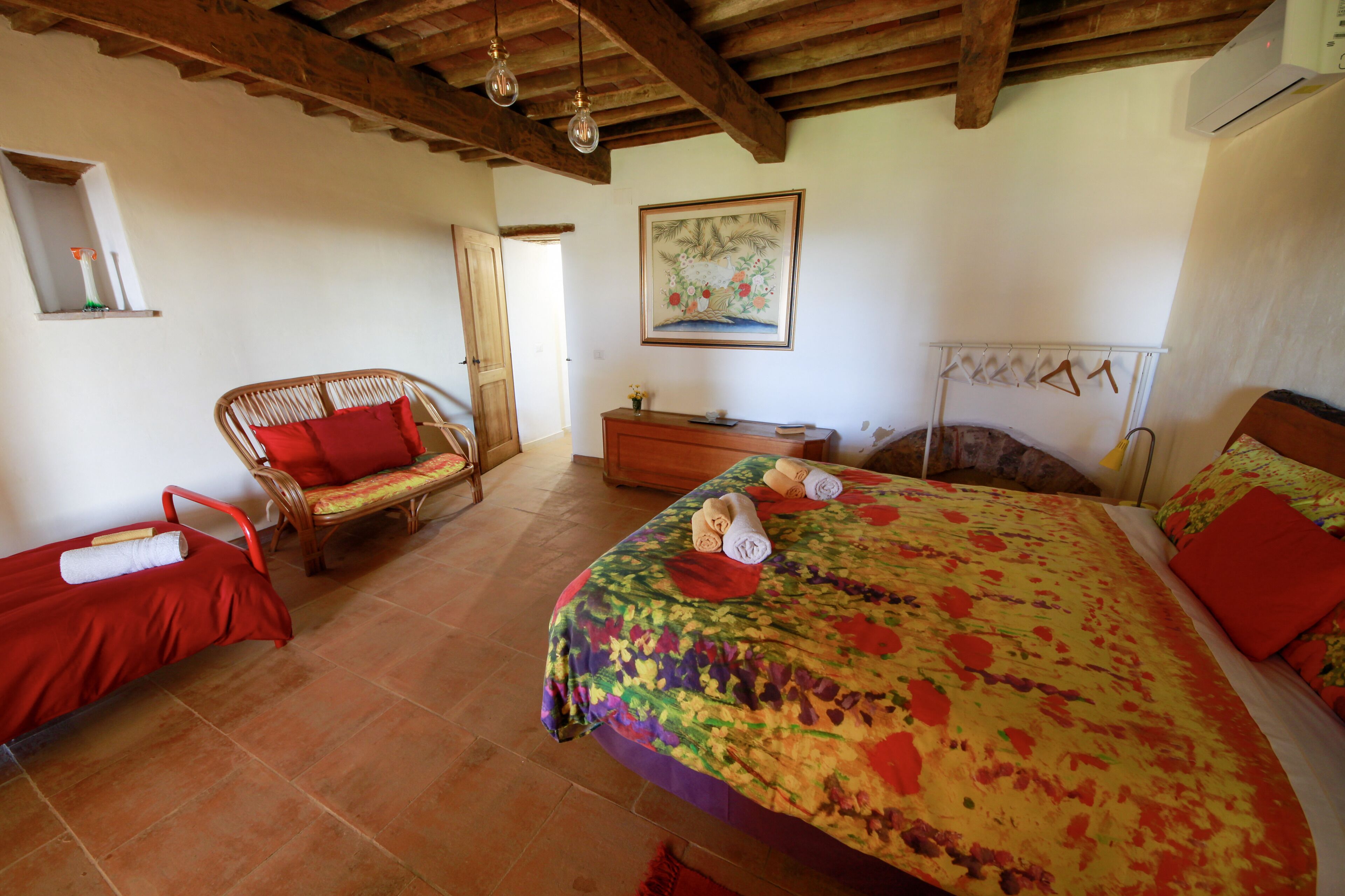 A bedroom with a bed, a chair, a dresser, and a painting on the wall.