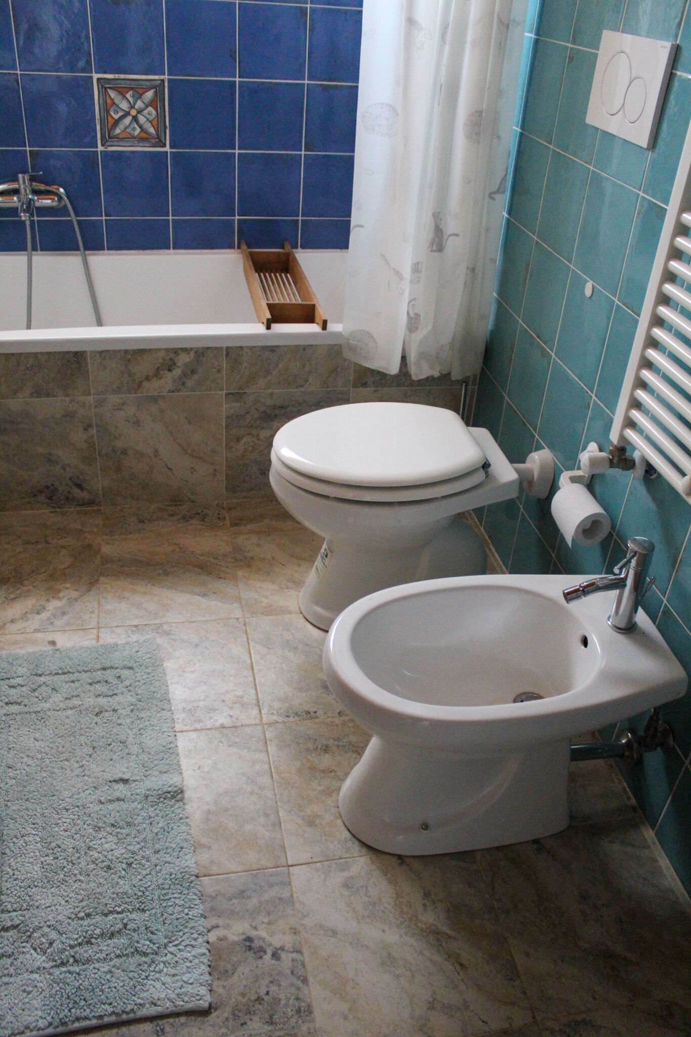 A bathroom with a toilet, bidet, and bathtub.