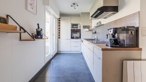 Une cuisine moderne équipée d’un four à micro-ondes, d’un four traditionnel et d’une machine à café.