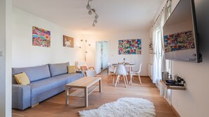 Un salon moderne avec un canapé, une table basse et un coin repas.