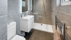 Ein modernes Badezimmer mit Dusche, Toilette und Waschbecken.