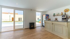 A spacious kitchen with a large window, a built-in coffee machine, and a shelf with various bottles. - Rustic Spa Retreat in Netos (Netos  Almagreira)