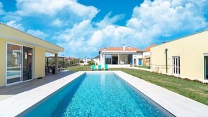 A rectangular swimming pool with a clear blue water surface, surrounded by a light-colored deck. - Rustic Spa Retreat in Netos (Netos  Almagreira)