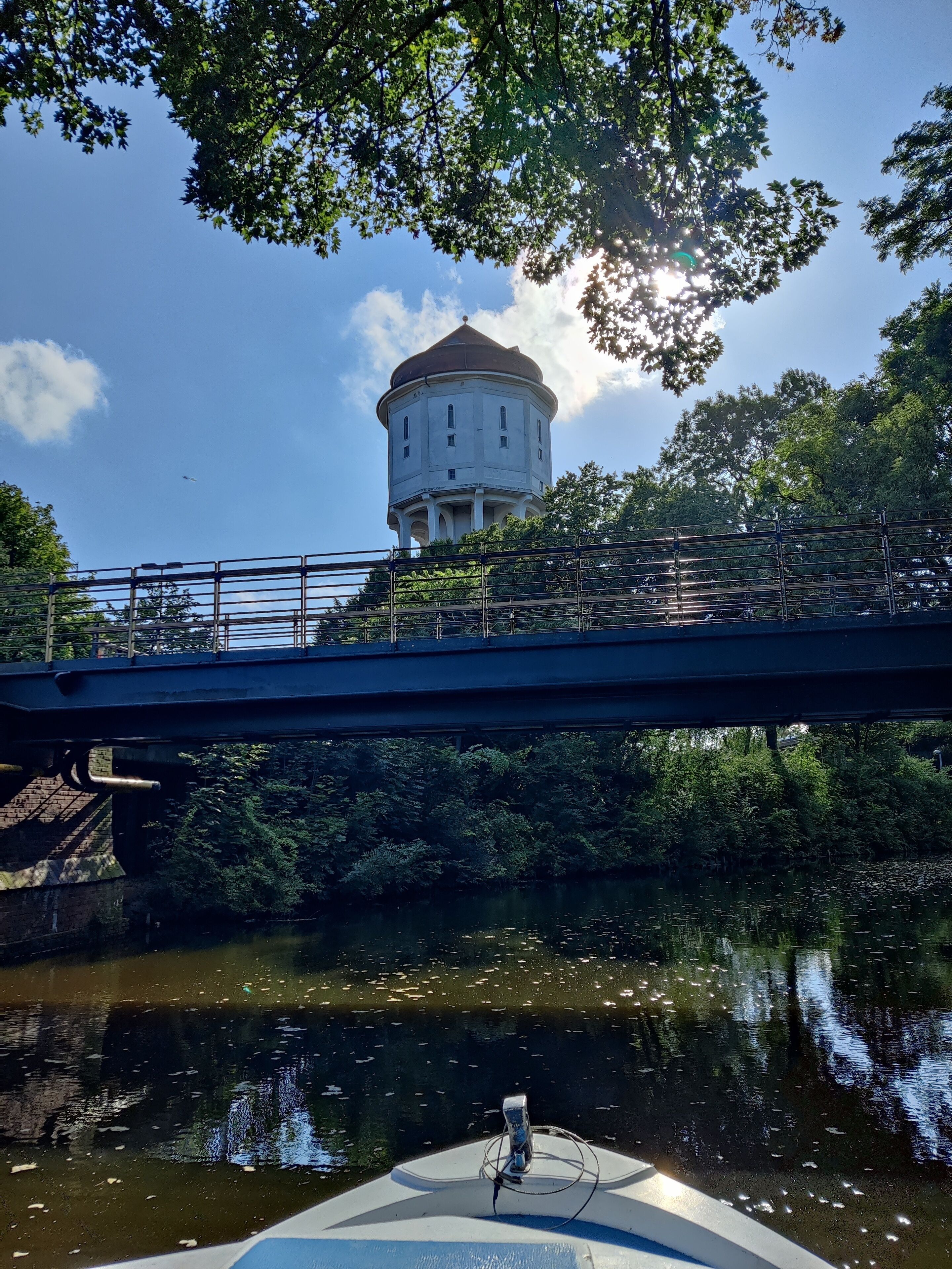 A bridge over a river with a water tower in the background.
