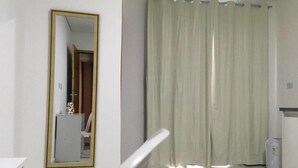 A room with a large mirror, a white radiator, and a green curtain. - Hotel 34 (Guarulhos)