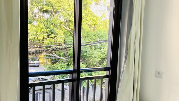 A room with a large window, a white table, and a white chair. - Hotel 34 (Guarulhos)