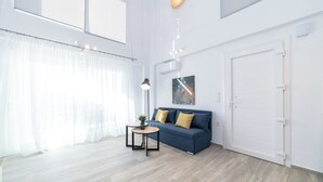 Una sala moderna con un sofá, una mesita redonda y una lámpara.