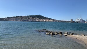 A coastal cityscape with a prominent hill, a large cruise ship docked, and clear blue waters. - 1-bedroom apartment with garage and pool in Sète (Sète)