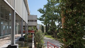 A modern building with large glass windows, a water feature, and a red railing. - 1-bedroom apartment with garage and pool in Sète (Sète)
