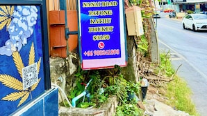 Señal del Hotel Hill Side Patong, que incluye la dirección y número de contacto.