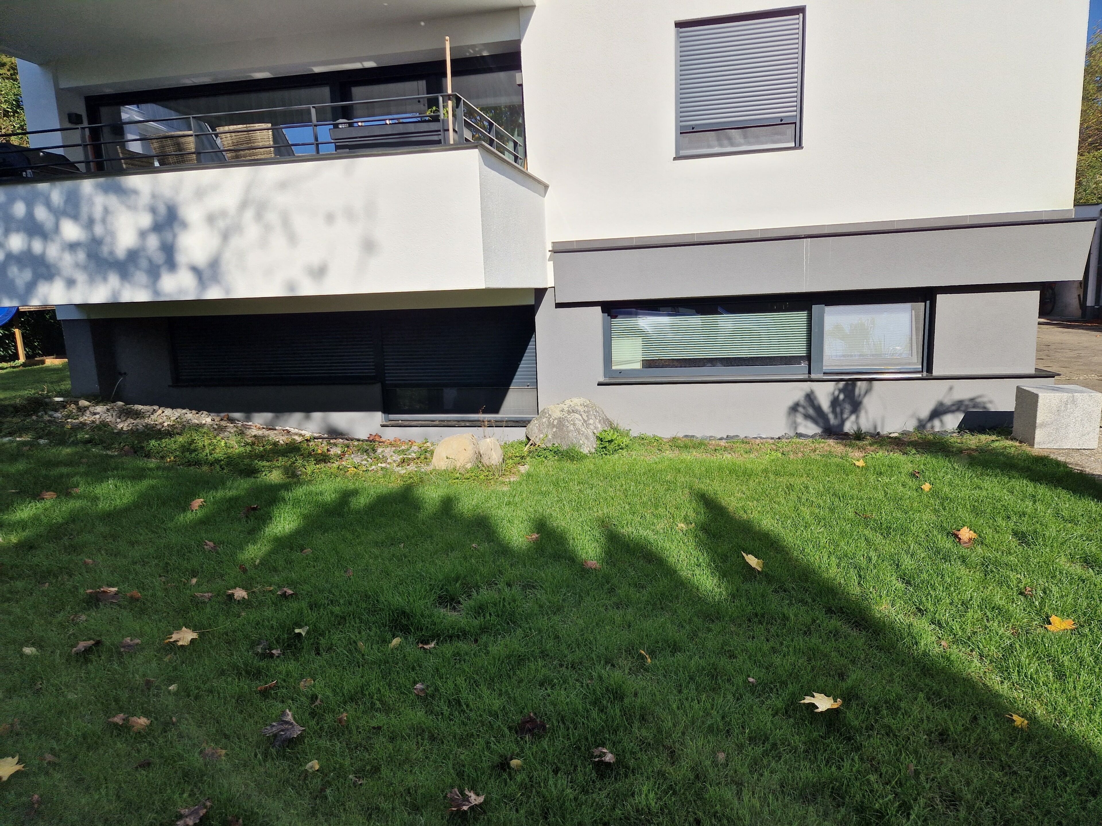 Ein modernes, zweistöckiges Gebäude mit Flachdach und großen Fenstern.