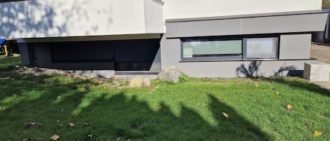 En moderne bygning med to etager, fladt tag og store vinduer.