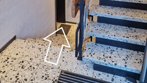 Eine Treppe mit Terrazzo-Boden, die zu einer Tür führt.