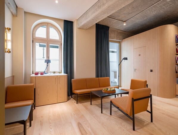 A modern living room with a wooden cabinet, a sofa, a coffee table, and a chair.