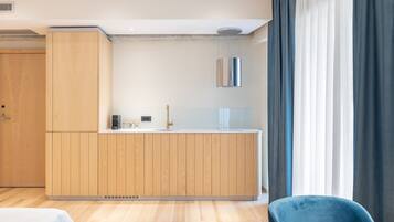 A modern kitchen with wooden cabinets, a countertop, and a hanging light fixture.
