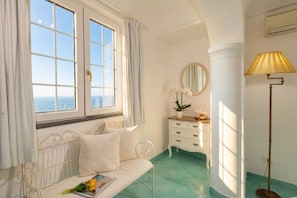 A room with a bed, a bedside table, a lamp, a dresser, and a window with curtains. - Villa Poesia - A Comfortable Stay (Praiano)