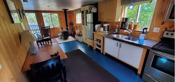 A compact kitchen with a stove, sink, and wooden cabinets. - Oceanfront lodge with all the amenities for a family vacation (Ellsworth)