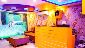 A reception area with a modern design, including a reception desk, seating area, and a wall-mounted air conditioner.