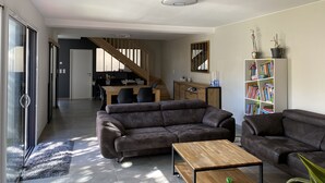 Un salón espacioso con un conjunto de sofás, una mesa de centro y una estantería llena de libros.