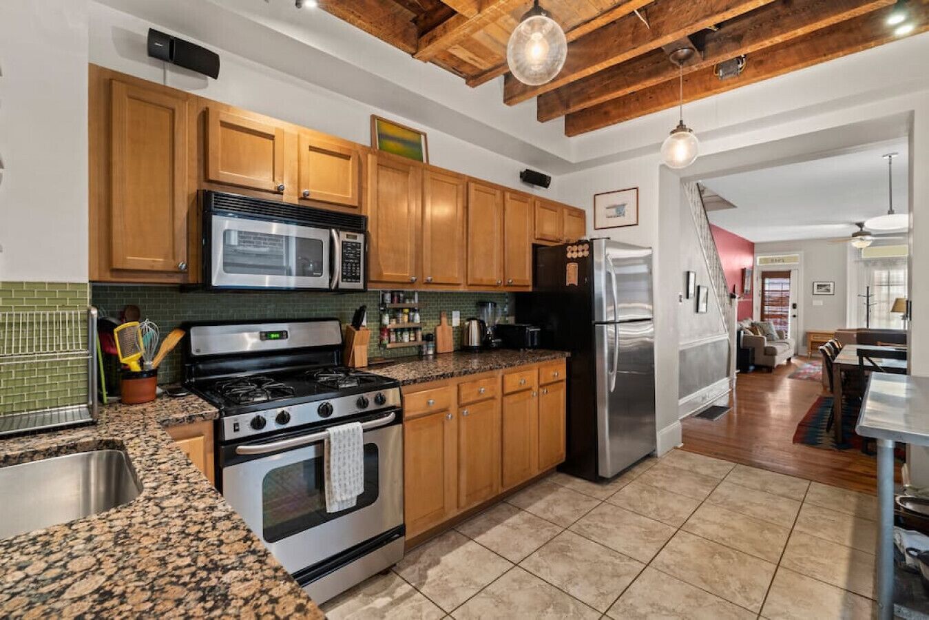A kitchen with wooden cabinets, stainless steel appliances, granite countertops, and a visible backsplash.