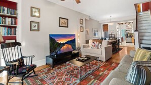 A living room with a TV, a sofa, a coffee table, and a patterned rug. - Fairmount Neighborhood Gem! (Philadelphia)