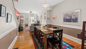 A spacious living area with a dining table, chairs, and a colorful rug. - Fairmount Neighborhood Gem! (Philadelphia)