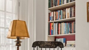 A room with a rocking chair, a lamp, and a bookshelf. - Fairmount Neighborhood Gem! (Philadelphia)