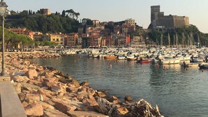 A coastal town with a marina filled with boats, a rocky breakwater, and historic buildings in the background. - #1 Cinque Terre, Tuscany, Liguria, Lerici (Liguria)