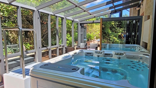 A hot tub area with a glass enclosure, surrounded by outdoor furniture and greenery. - Stylish Villa (6 or 8 bedrooms) with Private Pool, 40 minutes from Florence (Pistoia)