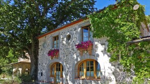 A stone building with arched windows and flower boxes. - Stylish Villa (6 or 8 bedrooms) with Private Pool, 40 minutes from Florence (Pistoia)