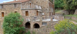Un bâtiment en pierre doté de nombreux balcons, de portes en arc de cercle et d’un escalier.