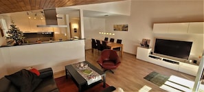 Relax in this open-plan living space with a sofa, coffee table, and flat-screen TV.