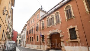 Una estrecha calle adoquinada bordeada de edificios históricos con puertas de arco y contraventanas tradicionales.