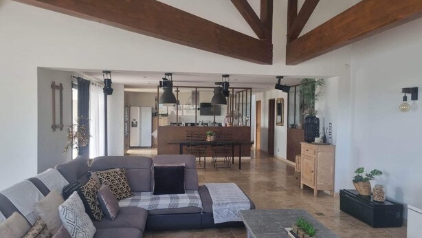 A modern living room with a sofa, a dining area, and a kitchen in the background. - Spacious VILLA 286 m2 overlooking the Sainte Victoire, garden, swimming pool. (Pertuis)