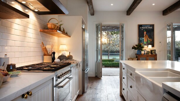 A modern kitchen with white cabinetry, a gas stove, and a wooden ceiling. There is a window leading to a garden. - The French House-Luxury Country Retreat (Trentham)