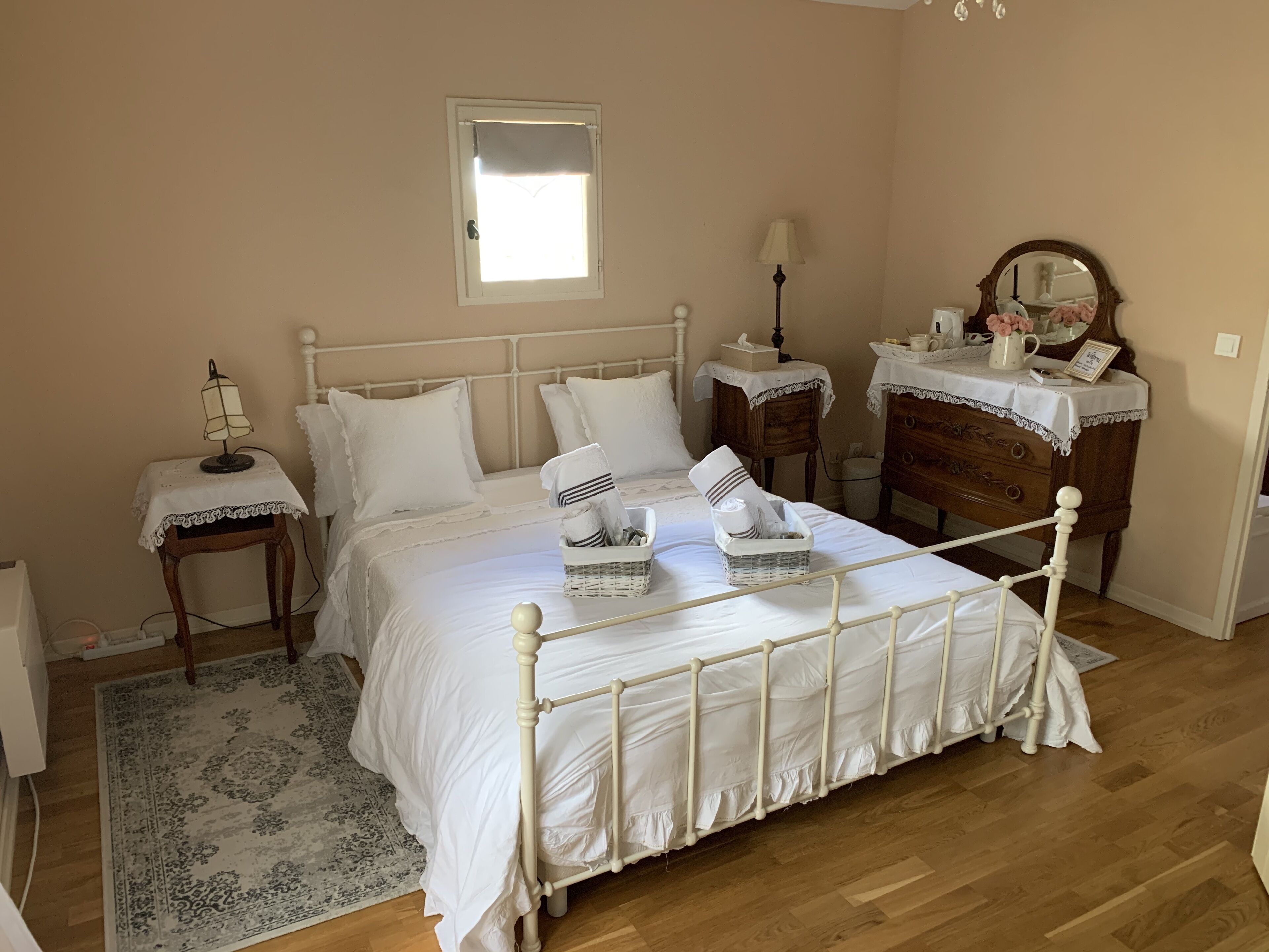 Ein Schlafzimmer mit Bett, Nachttischen, einem Schminktisch und einem Spiegel.