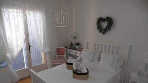 A bedroom with a bed, a bedside table, a chair, a dresser, and a wall decoration. - Beautiful Villa, big pool,  overlooking valley, walking distance to town.  (Seillans)
