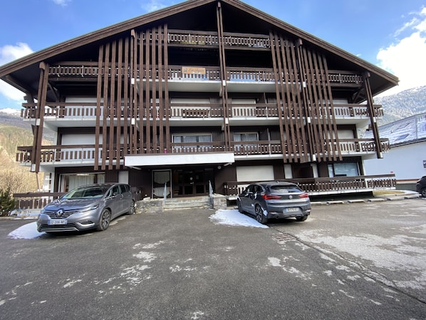 A multi-story building with balconies and a parking area. - Seasonal rental Contamines Montjoie 5 minutes from the ski lifts in winter (Les Contamines-Montjoie)
