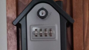 Un dispositivo electrónico gris con teclado, sobre una superficie de madera.