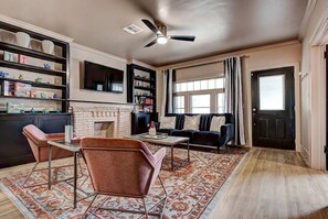 Un salon avec une cheminée, un canapé, une table basse et une bibliothèque.