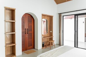 A bedroom with a large bed, wooden wardrobe, a mirror, and a sliding glass door to the outside. - Sunshine City View Villa 6BR wth a private Heated Pool (Cimenyan)