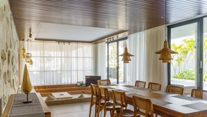 A modern dining area with a long wooden table, wooden chairs, and hanging pendant lights. - Sunshine City View Villa 6BR wth a private Heated Pool (Cimenyan)