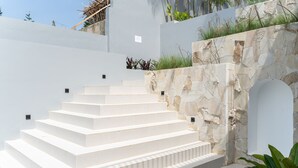 A set of white stone steps leading up to a white wall with a stone wall and plants on the side. - Sunshine City View Villa 6BR wth a private Heated Pool (Cimenyan)