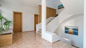 Een modern interieur met een trap, houten deuren en een kamerplant.