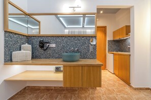 A modern kitchen with a skylight, a blue sink, wooden cabinets, and a built-in radio.