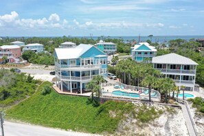 A coastal property with multiple buildings, a swimming pool, and a beach view.