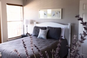A bedroom with a bed, a window, and a wall-mounted artwork. - Pura Vida Private Pool, Wi-Fi, @ Frio River Vacation Rentals (Concan)