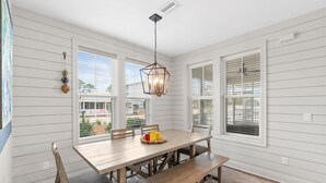 A dining area with a wooden table, benches, and a hanging light fixture. - (4 Minute Walk to Beach) Screened in porch & MBR  on ground level (Cape San Blas)
